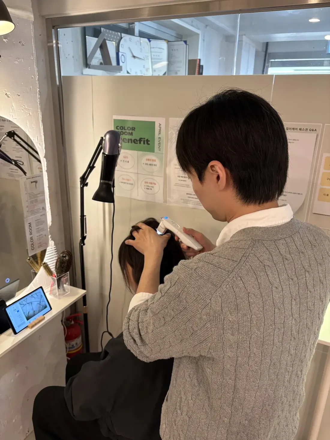 두피에 기기를 대고 태블릿 화면으로 상태를 확인하는 모습