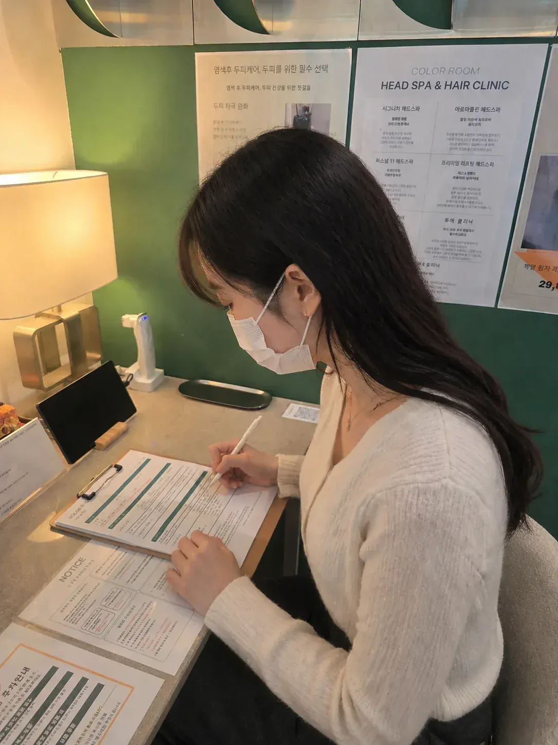 마스크를 쓴 고객이 상담 차트를 작성하는 모습